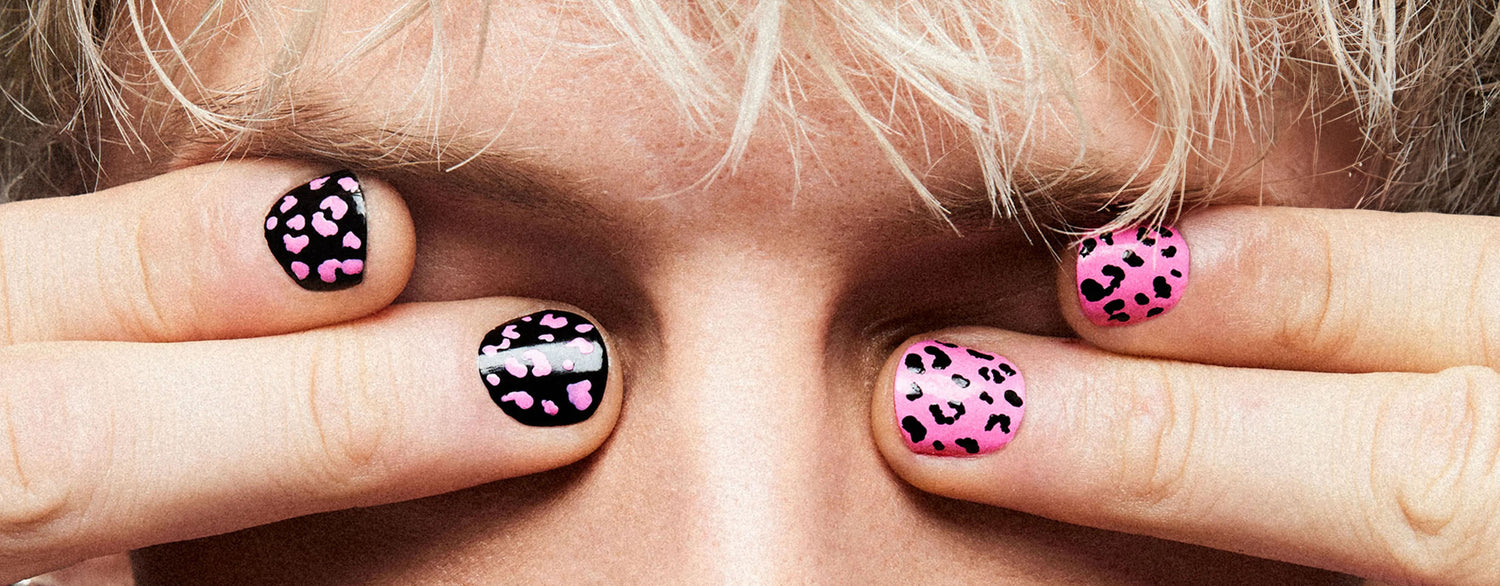 A blond man with black and pink nail art designs over his eyes